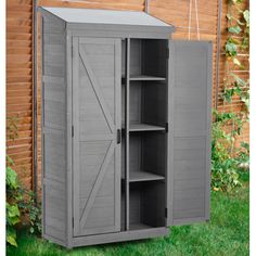 an outdoor storage shed with its doors open and shelves on the outside, in front of a wooden fence