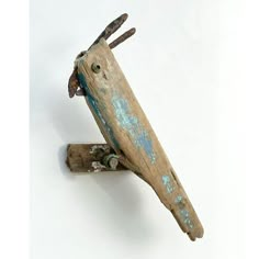 a piece of driftwood that has been painted blue and rusted to look like a bird