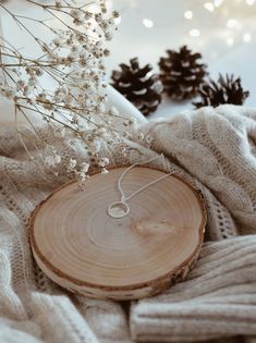 a piece of wood that has been placed on top of a blanket next to some flowers