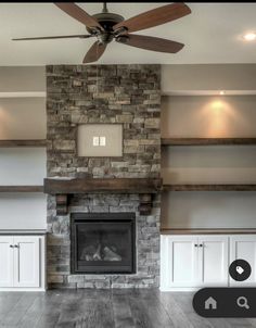 a living room with a fireplace and ceiling fan