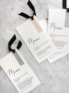 the wedding stationery is laid out on top of the marble table and tied with black ribbon