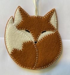 an ornament made to look like a fox's head is hanging on a white background