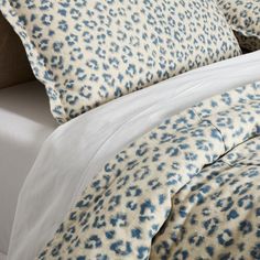 a bed with blue and white leopard print on it