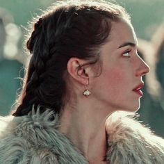 a woman in a fur coat looking off into the distance