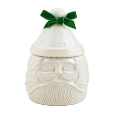 a white ceramic jar with a green bow on top