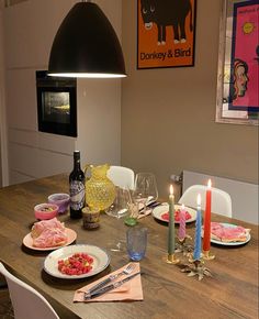 a wooden table topped with plates and candles