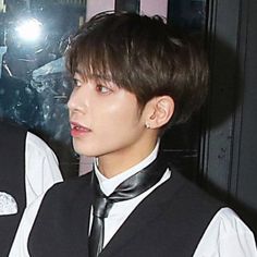 two young men wearing black ties and vests