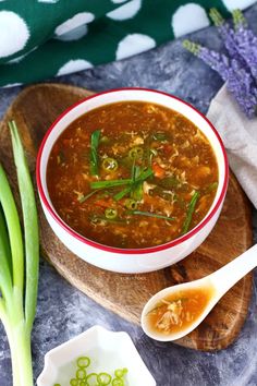 a bowl of soup on a wooden board