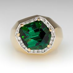 This exquisite cocktail ring is centered with one (1) freeform step cut natural tourmaline set into a six-prong setting and bordered with twenty-two (22), channel set, round brilliant cut diamonds. The ring measures 14.6mm at the top, rises 14.0mm above the finger, tapering to 3.3mm wide and 1.7mm thick at the base of the shank. Signed Schmidt. This ring is currently a size 7. Fine Jewelry Tsavorite Diamond Ring For Formal Occasions, Formal Emerald Cut Tsavorite Gemstone, Elegant Tourmaline Diamond Ring With Accent Stones, Luxury Tourmaline Ring With Center Stone, Formal Yellow Gold Emerald Ring, Formal Emerald Gemstones With Accents, Formal Tourmaline Ring With Bezel Setting, Formal Tourmaline Rings With Bezel Setting, Formal Emerald Ring With Gemstone Accents