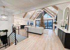 a living room filled with furniture and a christmas tree in the middle of the room