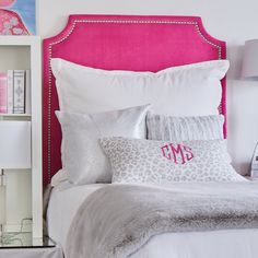 a bed with pink headboard and white sheets