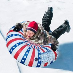 a young boy is laying down on an inflatable snow tube with the american flag painted on it