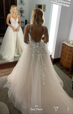 a woman in a wedding dress looking at herself in the mirror