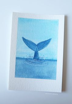 a watercolor painting of a blue whale tail flups out of the ocean waters