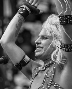 a woman with her hands in the air while wearing chains and bracelets on top of her head