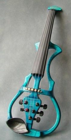 a small blue instrument is sitting on a gray surface and it's made out of wood