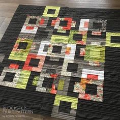 a black and yellow quilt is on the floor