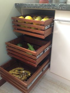 an open drawer in a kitchen filled with fruits and vegetables