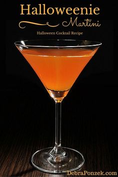 the halloween martini cocktail is served in a coupe glass with orange liquid and garnish