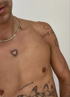 a shirtless man with tattoos on his chest