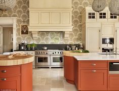 a large kitchen with an island in the middle and two pendant lights hanging from the ceiling