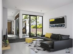 a modern living room with black leather furniture and yellow accent pillows on the couches