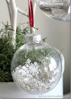 a christmas ornament hanging from a tree with snow flakes on it's bottom