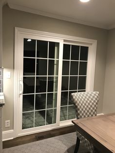 a dining room table and chairs in front of a sliding glass door