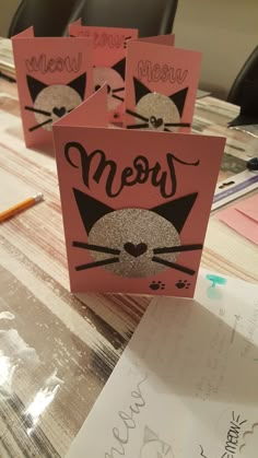 three pink boxes with black cats on them and the word meow written in cursive writing