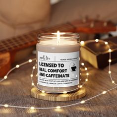 a candle that is sitting on a table next to some string lights and a guitar