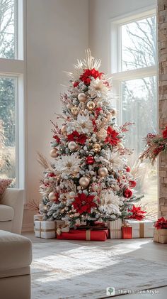 a decorated christmas tree in a living room with red and white ornaments on the top