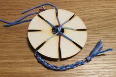 a piece of wood sitting on top of a table next to a blue and white string