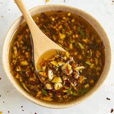 a wooden spoon in a bowl filled with soup