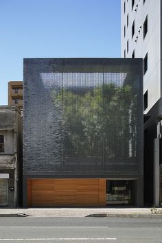 a large building with a wooden door on the side of it's face in front of other buildings