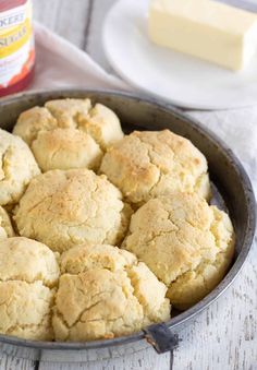 a pan filled with biscuits and butter on top of a table