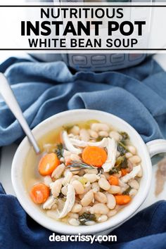 a bowl of white bean soup with carrots and spinach in it on a blue towel