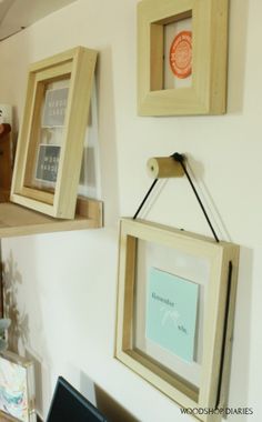 three wooden frames hanging on the wall above a laptop