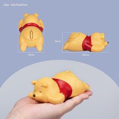 a hand holding a small toy with winnie the pooh on it's back