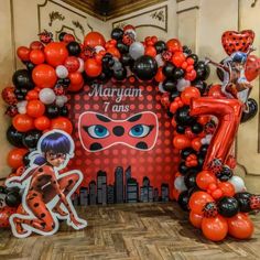 the balloon arch is decorated with ladybug balloons and an image of a mask