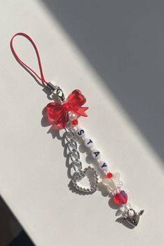 a red and white keychain with charms attached to it's back end