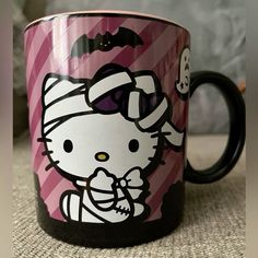 a hello kitty coffee mug sitting on top of a table