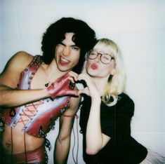 two people dressed up in costumes posing for a photo with one woman sticking out her tongue