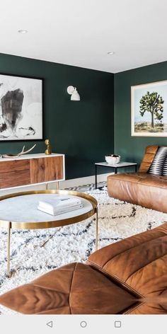 a living room with green walls and leather furniture in the center, along with pictures on the wall