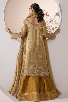 Embroidered Mustard Pakistani Wedding Dress in Kameez Gharara Style comes in Mustard and gold hues of this bridal making it a perfect option for a minimal barat look. The outfit is heavily embellished with zari, swarovski crystals, gota in bronze and gold hues. Paired with it is a crushed luxe organza dupatta with gota embellishments. The shirt is worn with sharara lined with mirror and threadwork at the border. The royal look of this bridal will bring attention to it at any event. Embroidered N Gold Floor-length Kurta With Sheer Dupatta, Gold Sharara With Gold Embroidery For Reception, Traditional Gold Palazzo Set With Zari Work, Gold Raw Silk Palazzo Saree Set, Elegant Palazzo Set With Gold Embroidery For Reception, Gold Anarkali Kurta With Sheer Dupatta, Traditional Palazzo Set With Gold Embroidery For Reception, Traditional Gold Palazzo Set With Gold Embroidery, Gold Embroidered Designer Palazzo Set