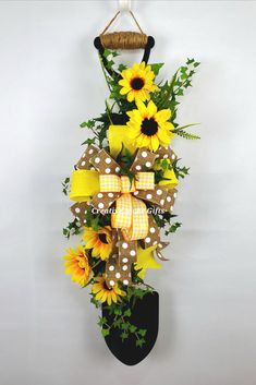 a sunflower and polka dot bow hanging on a wall with an umbrella holder attached to it