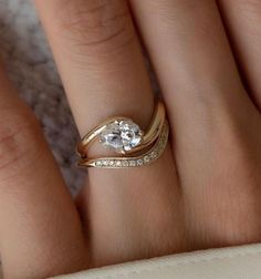 a woman's hand with a gold ring and two diamond rings on top of it