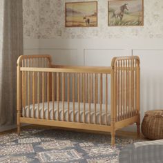 a baby crib in the corner of a room with two pictures on the wall