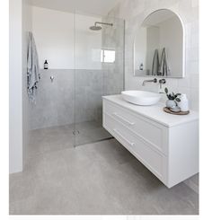 a bathroom with a sink, mirror and shower stall in the middle of it's walls