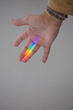 a person's hand with a multicolored object in the air