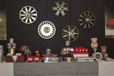 a table topped with lots of different types of items on top of a black wall